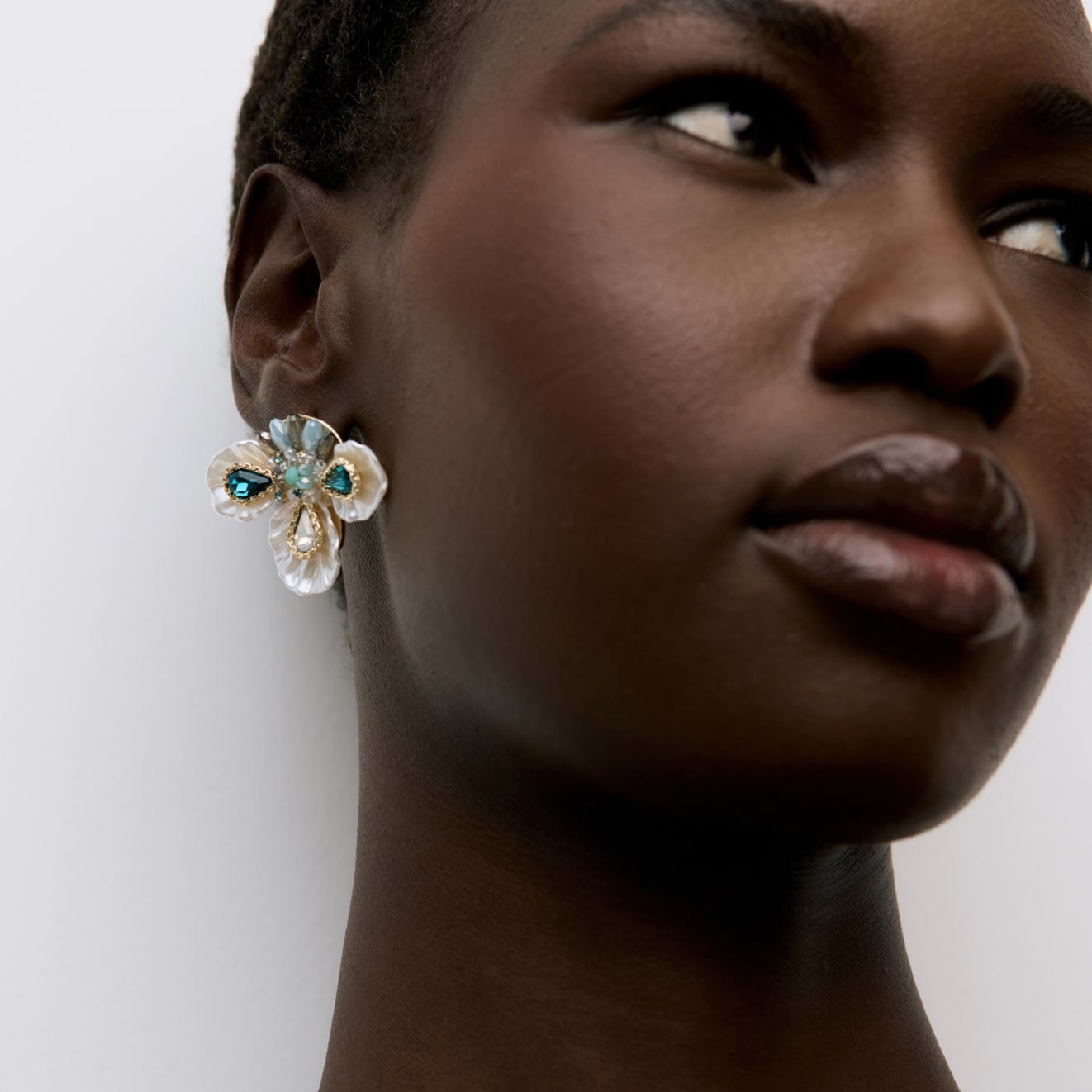 Model wearing a large floral stud earring